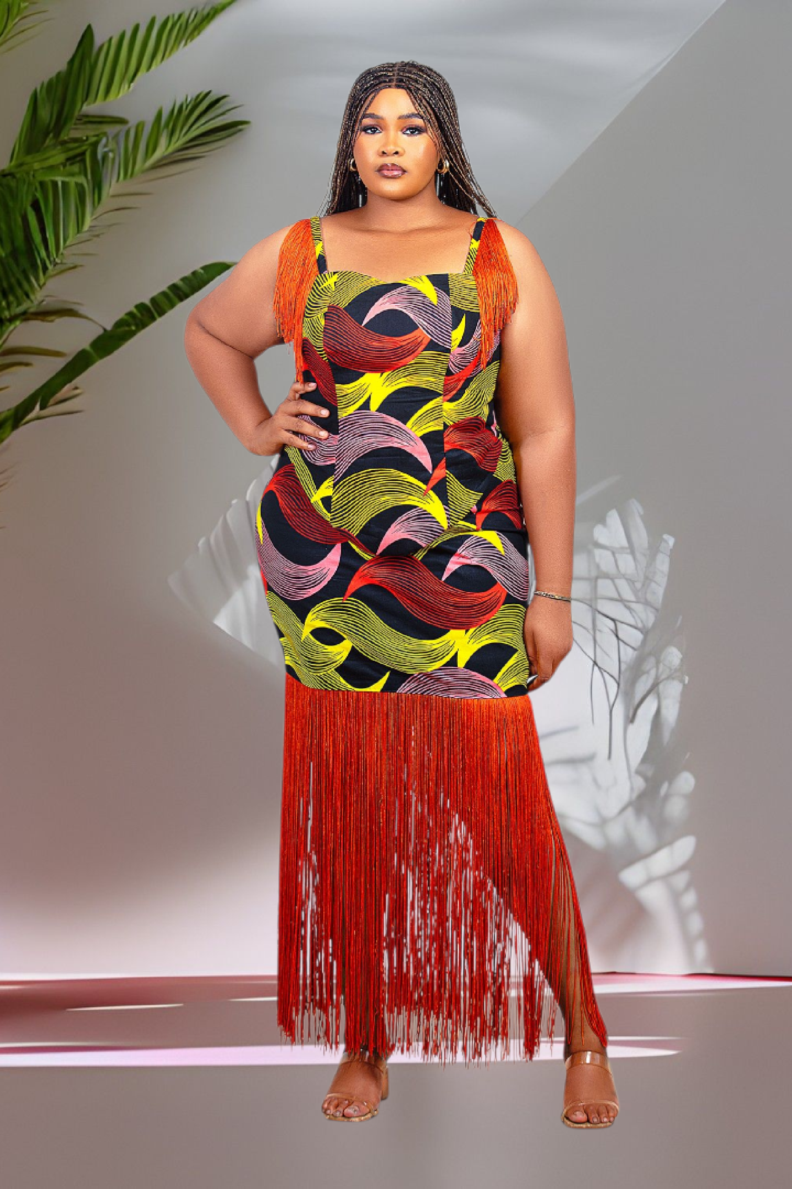Model wearing a colorful orange multicolor tassel top and skirt set dress with orange fringes against a neutral background