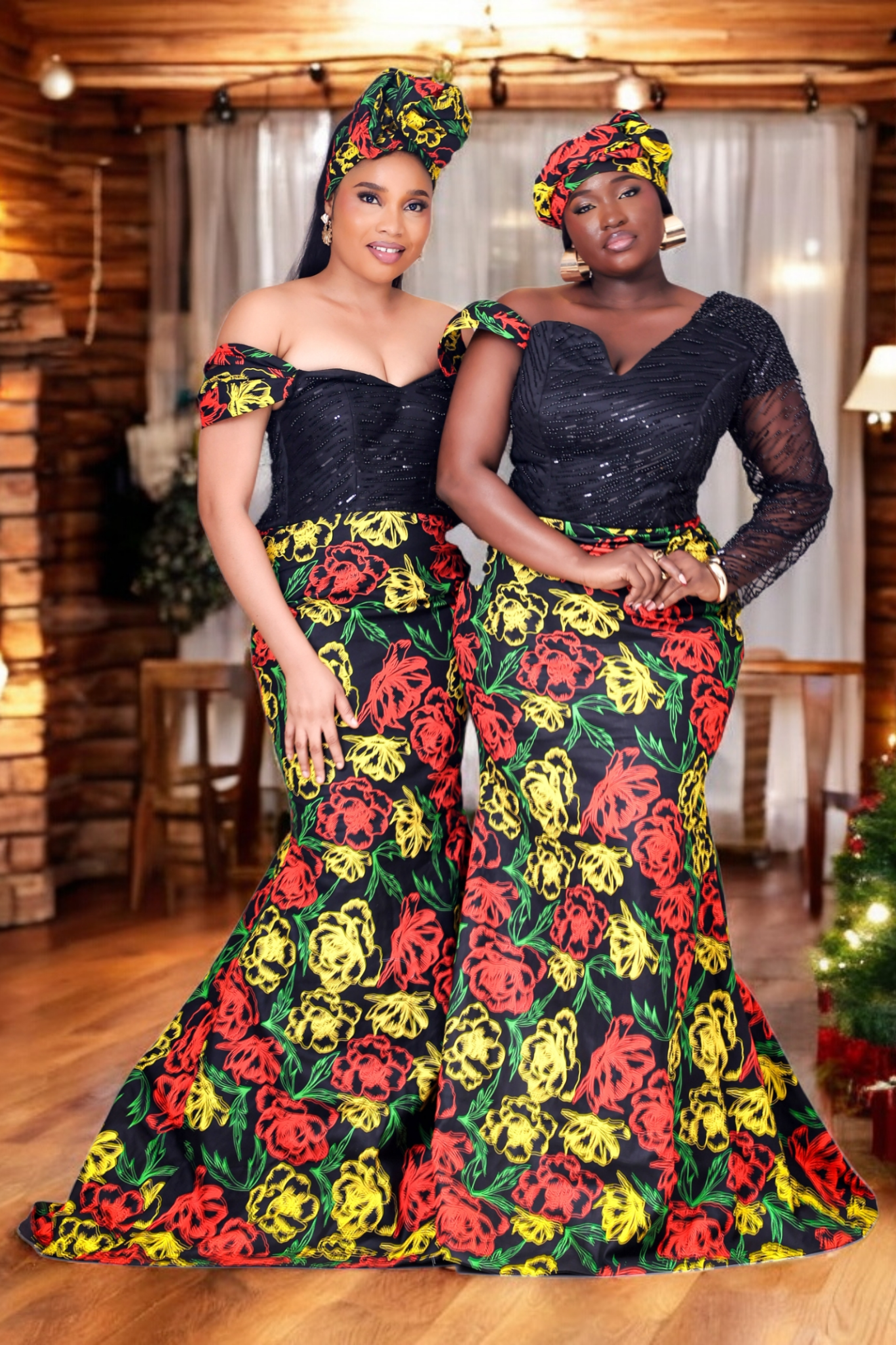 Women in a colorful floral African Print dress with embellished hand beaded upper bodice in black standing in front of a decorated Christmas tree and fireplace.