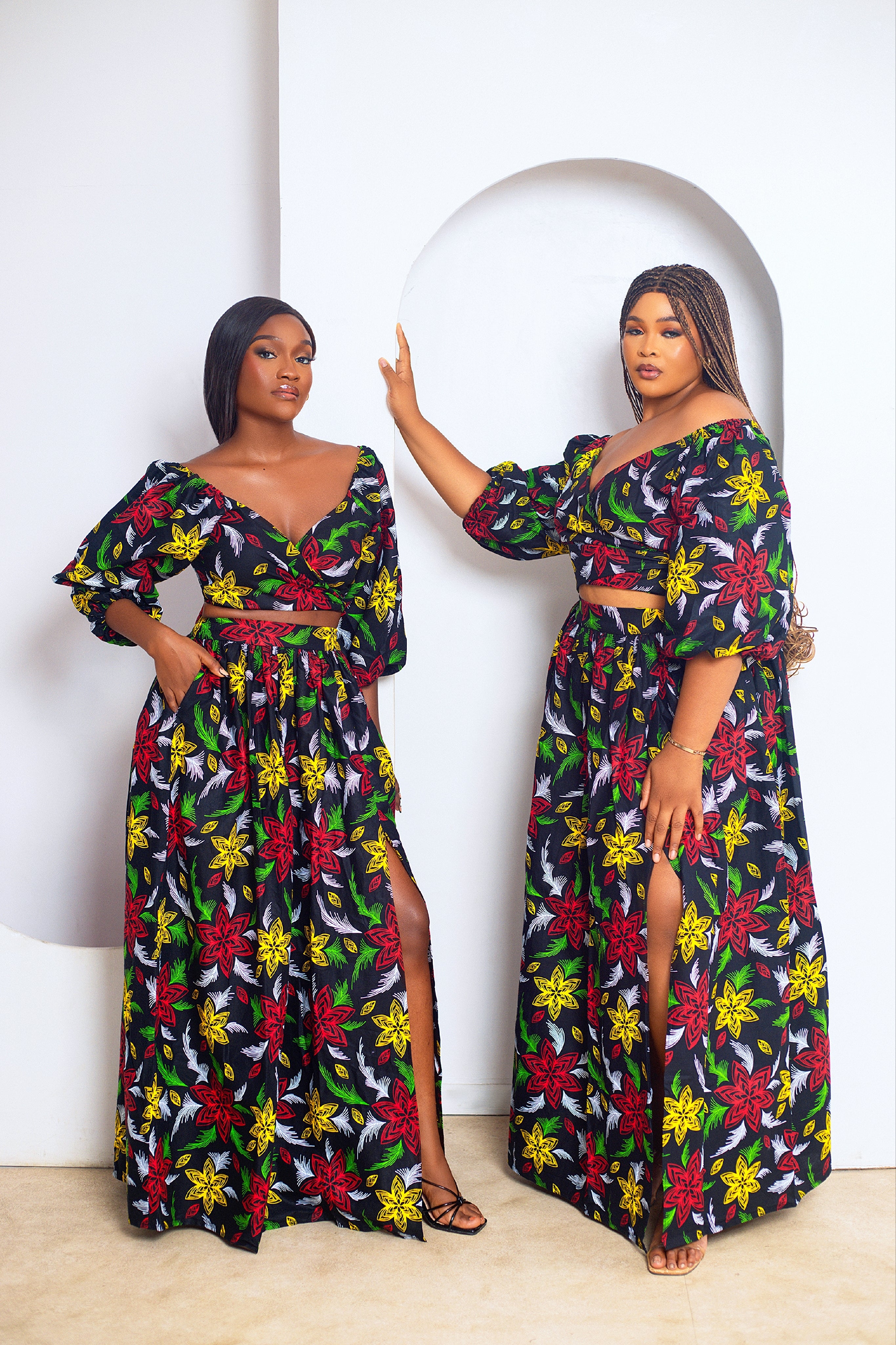 Woman wearing a colorful floral wrap top and maxi skirt dress set against a neutral background